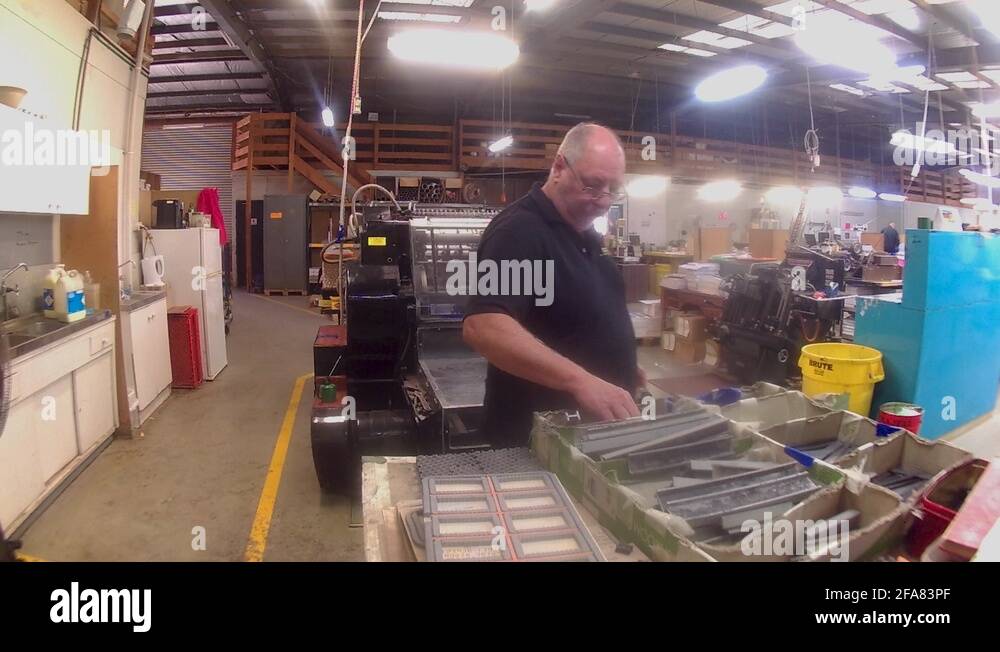 A printer at his printing press. Form cutting paper and checking the