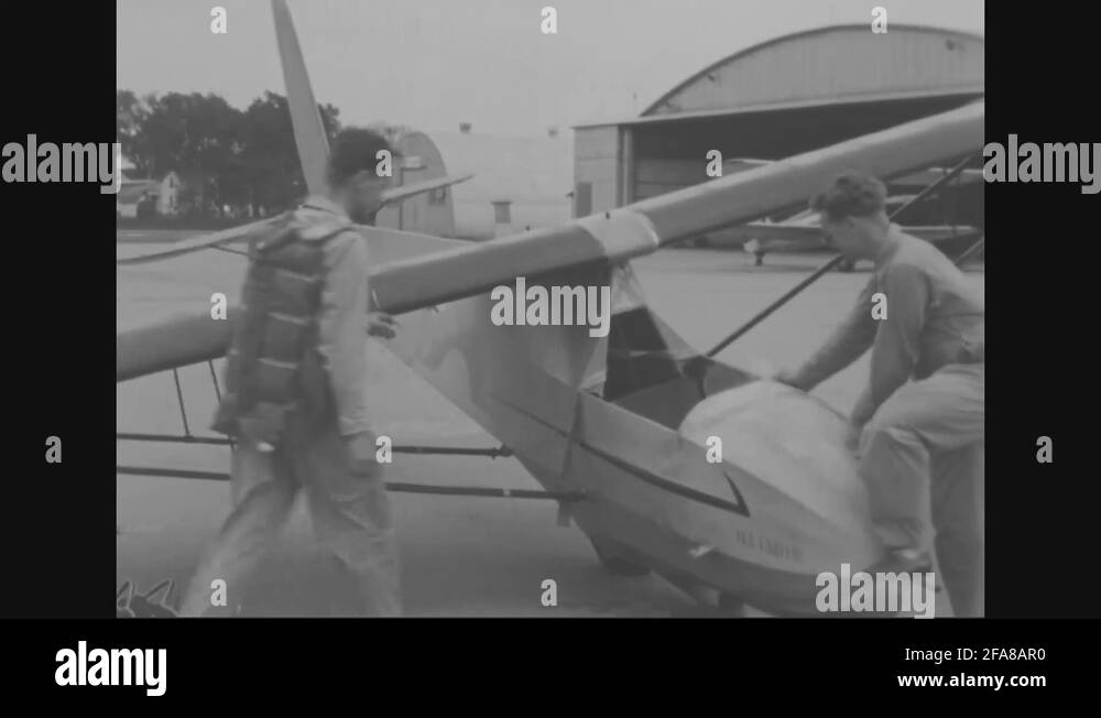 Glider pilot walks into frame and is assisted into aircraft 1953 Stock Video Footage Alamy