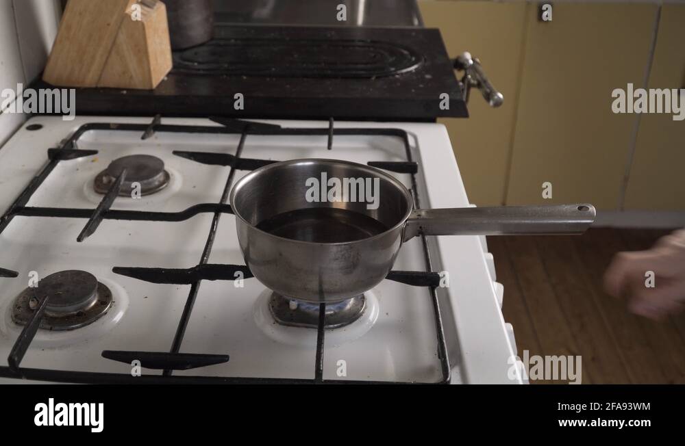Close up hands turning off gas stove. Picking up warm steel pot, hot