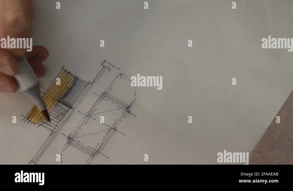 Architect sketching a building on tracing paper using a pen and markers