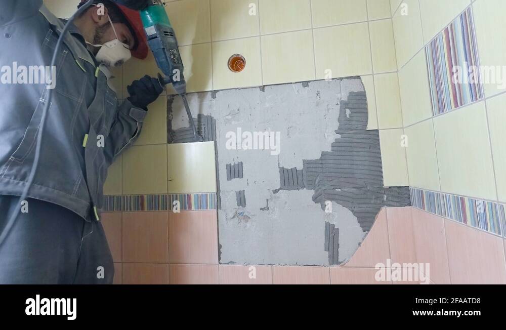 Demolition of old tiles with jackhammer. Renovation of old walls in the bathroom Stock Video