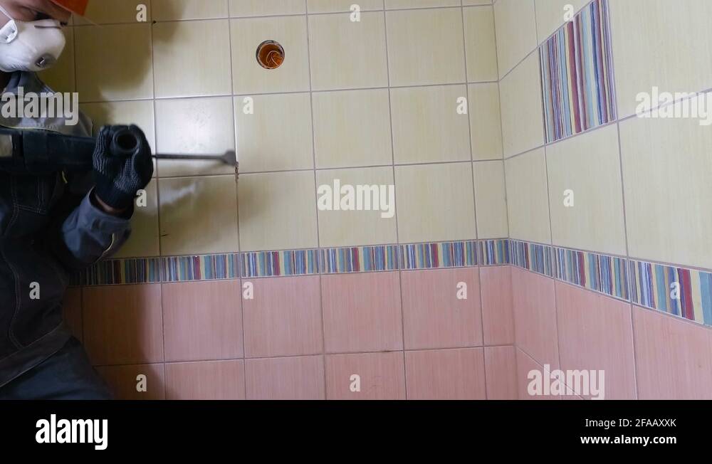 Demolition of old tiles with jackhammer. Renovation of old walls in the bathroom Stock Video