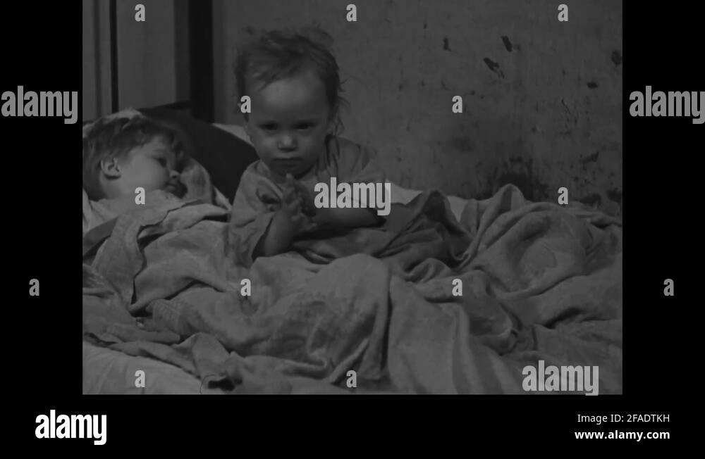 Two children share bed in a slum house 1939 Stock Video Footage Alamy