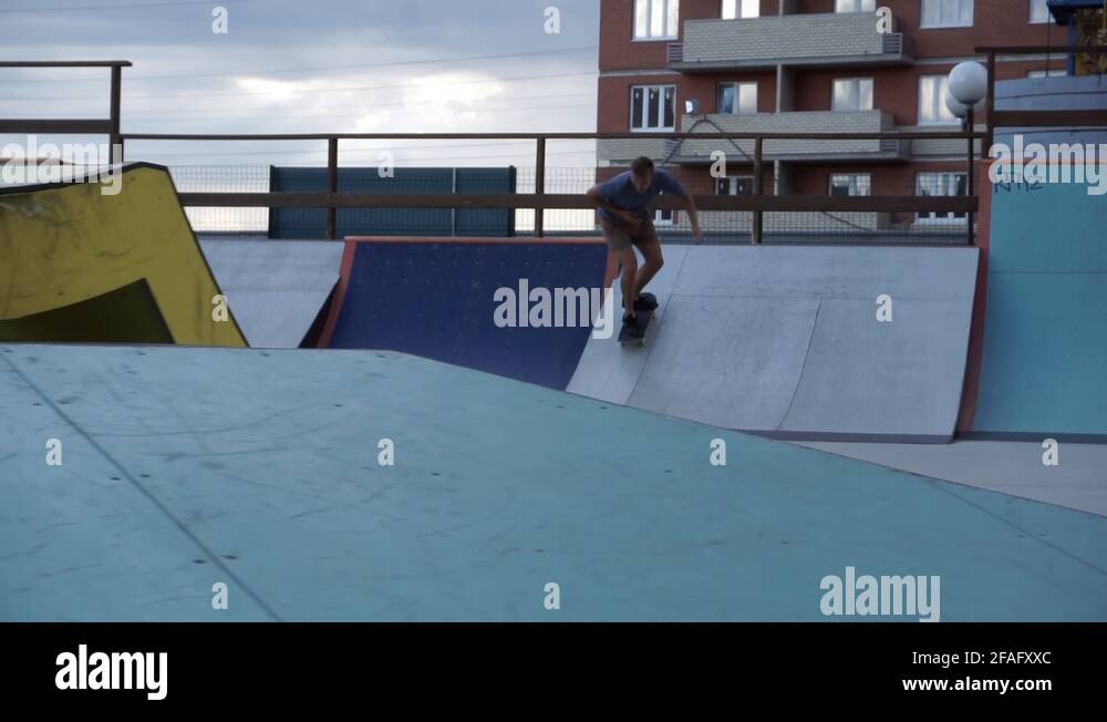 Skateboarder slides on railing Stock Video Footage Alamy