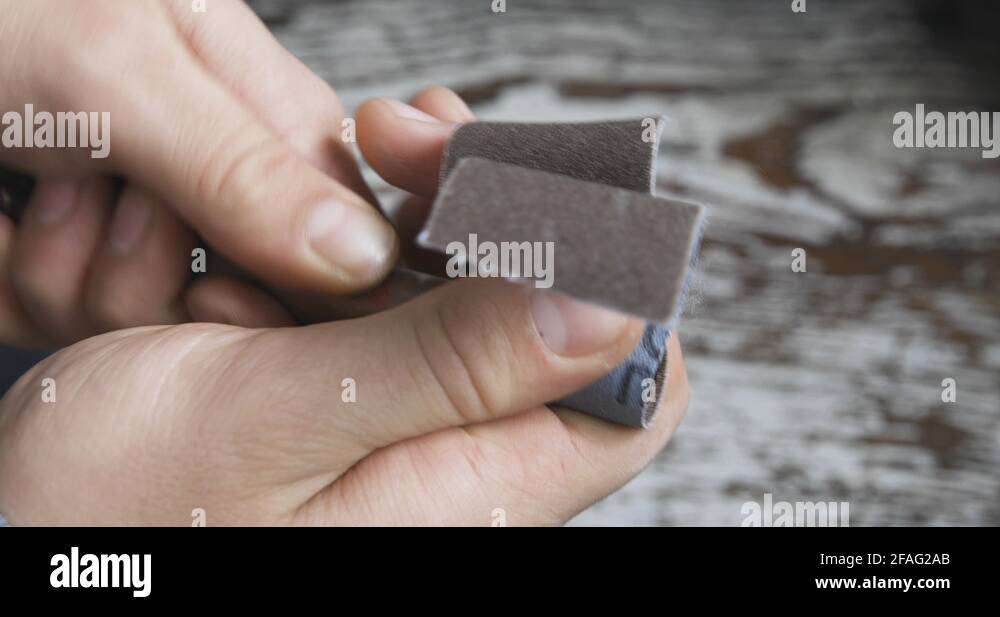 Male hands sanding a copper pipe before soldering for plumbing repair