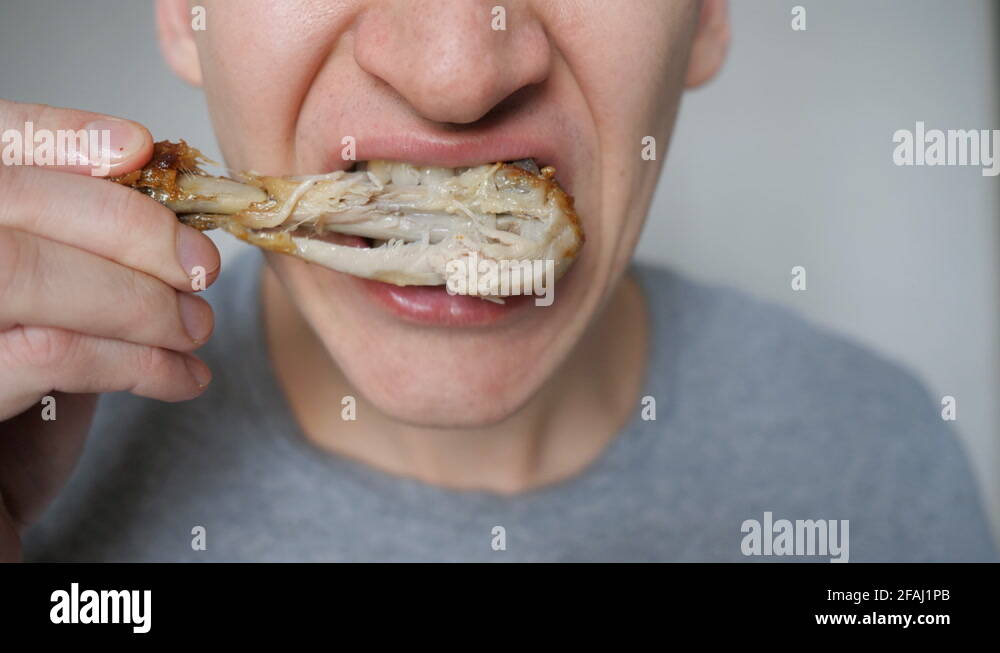 attractive hungry young man eating fast food meat chicken wings