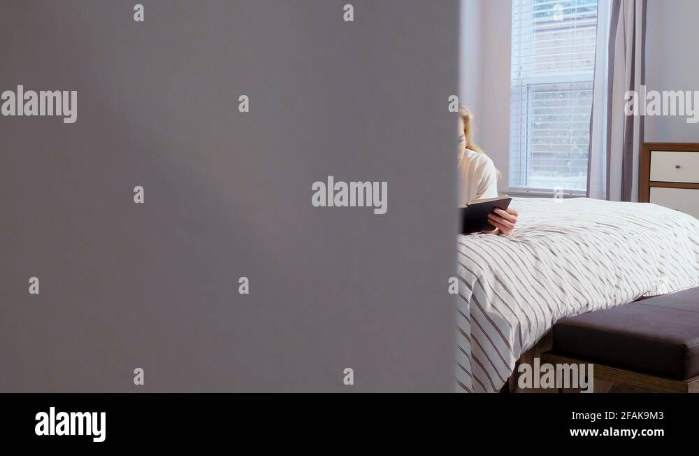 Woman lying on bed ready to write in diary, candid reveal shot from