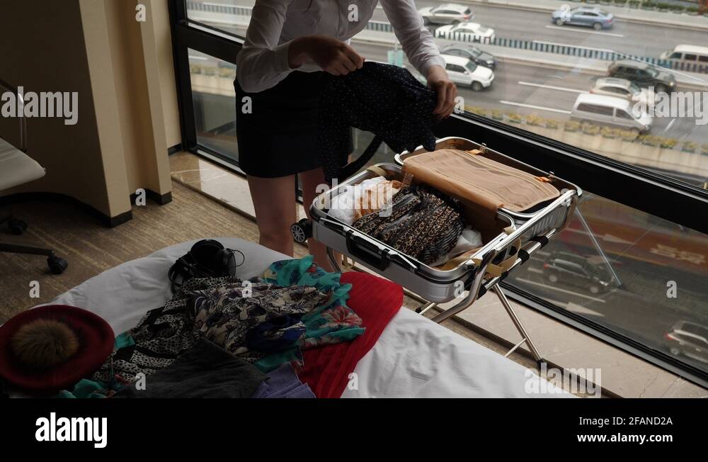 Business woman packing up suitcase, take clothes from bed and put into Stock Video Footage Alamy