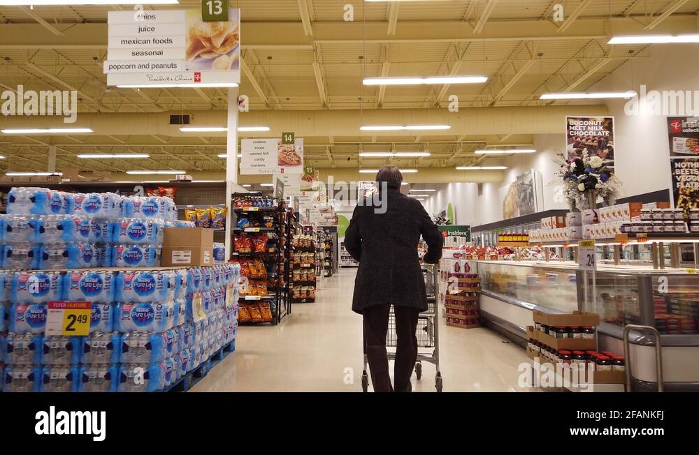 Man Walking Down Grocery Store Aisles Then Turning Into Junk Food Aisle