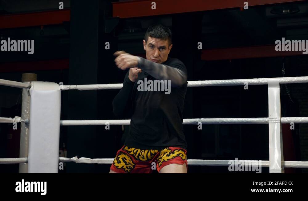 Muay Thai Fighter Training In Boxing Ring Kicks and Punches Fast In