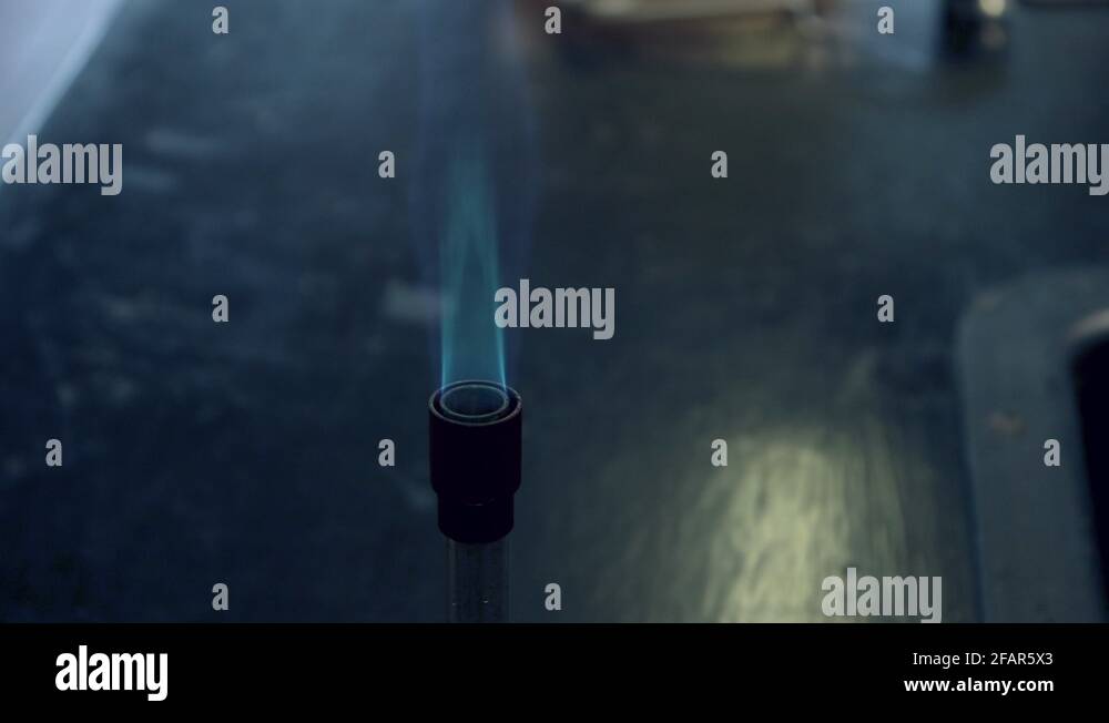 Close up of blue bunsen burner flame followed by strontium flame test