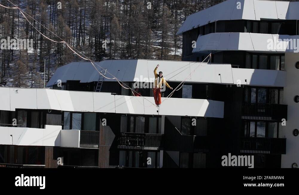 highliner walking and balancing on highline over the snow of a ski ...