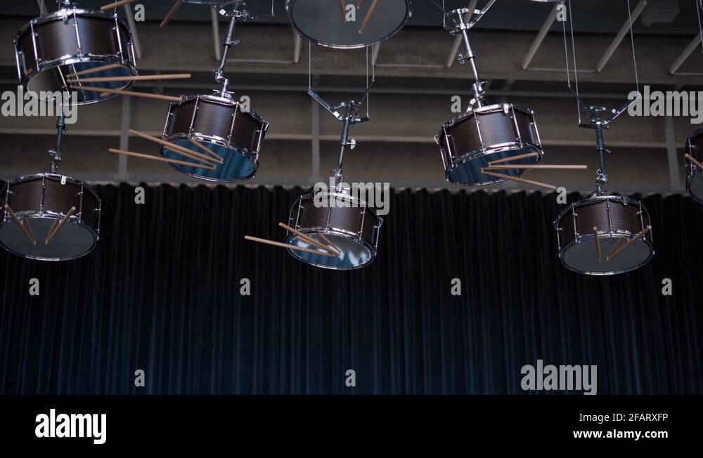 Drums hanging upside down from the ceiling with sticks Stock Video