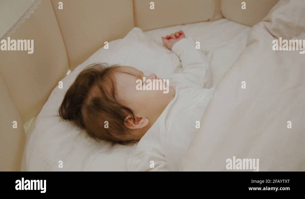 Beautiful little girl sleeping in her cot Stock Video Footage Alamy