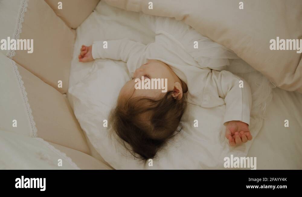 Beautiful little girl sleeping in her cot Stock Video Footage Alamy