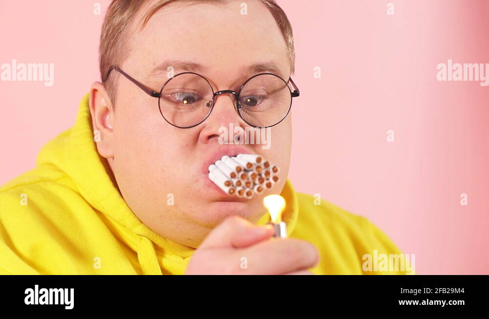 Stressed corpulent man trying to smoke a whole pile of cigarettes ...