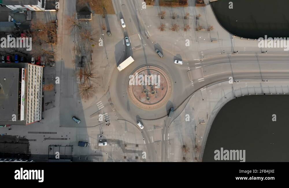 Overhead drone footage with cars driving in and out of a roundabout, on a Stock Video Footage