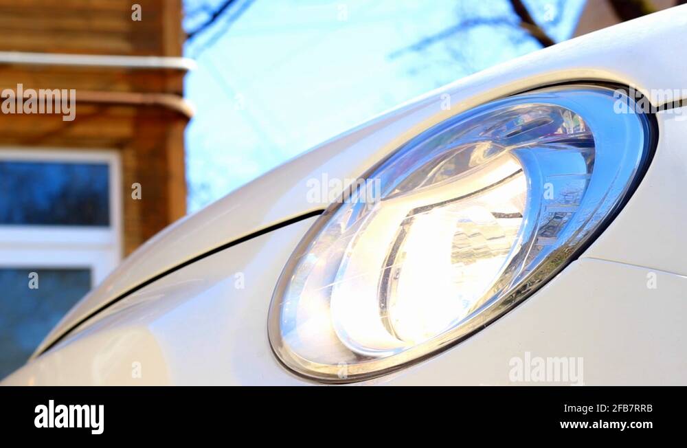 Side view of car headlight turning off followed by a reflection of
