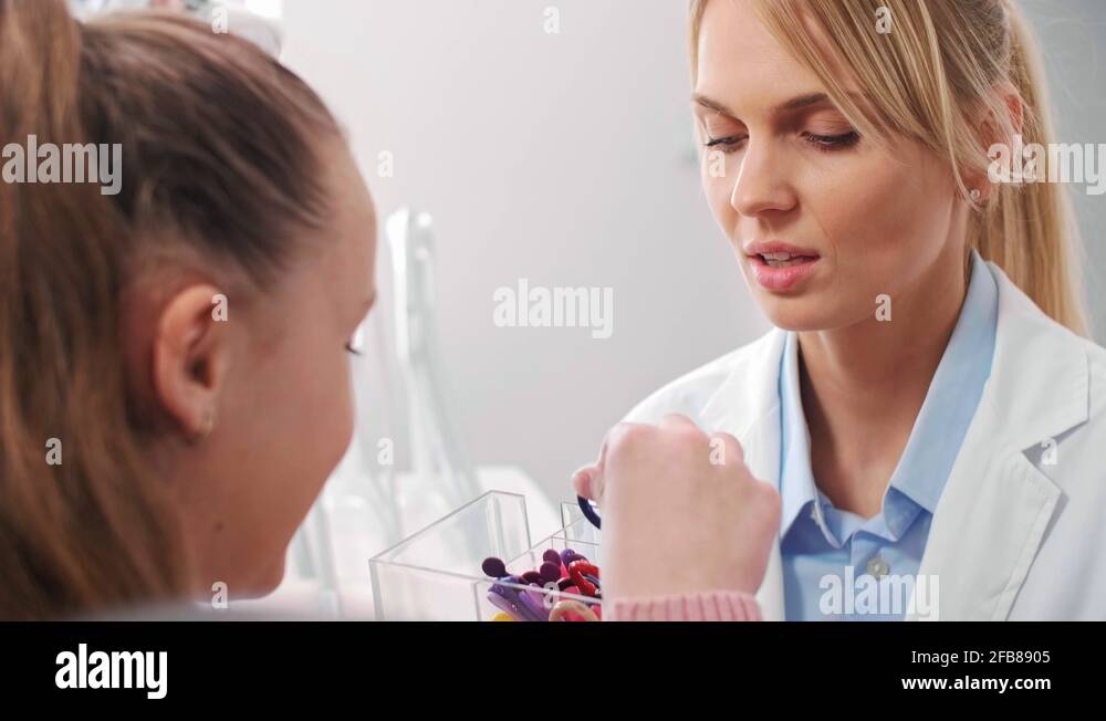 Teenage girl choosing the color of rubber bands for braces Stock Video