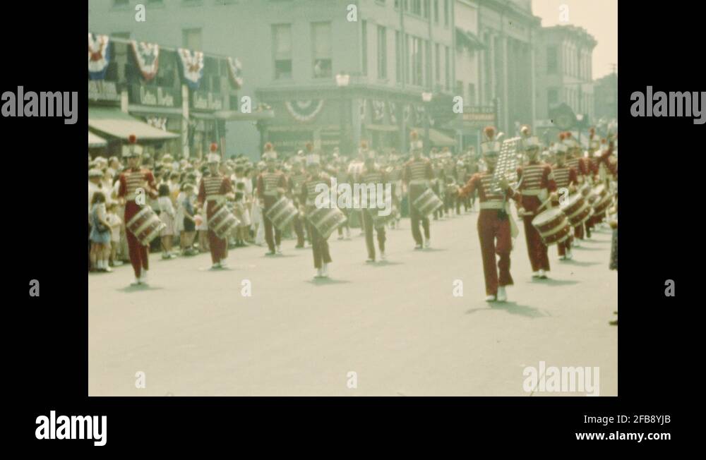1940s Marching bands and parade floats pass along crowded street Stock