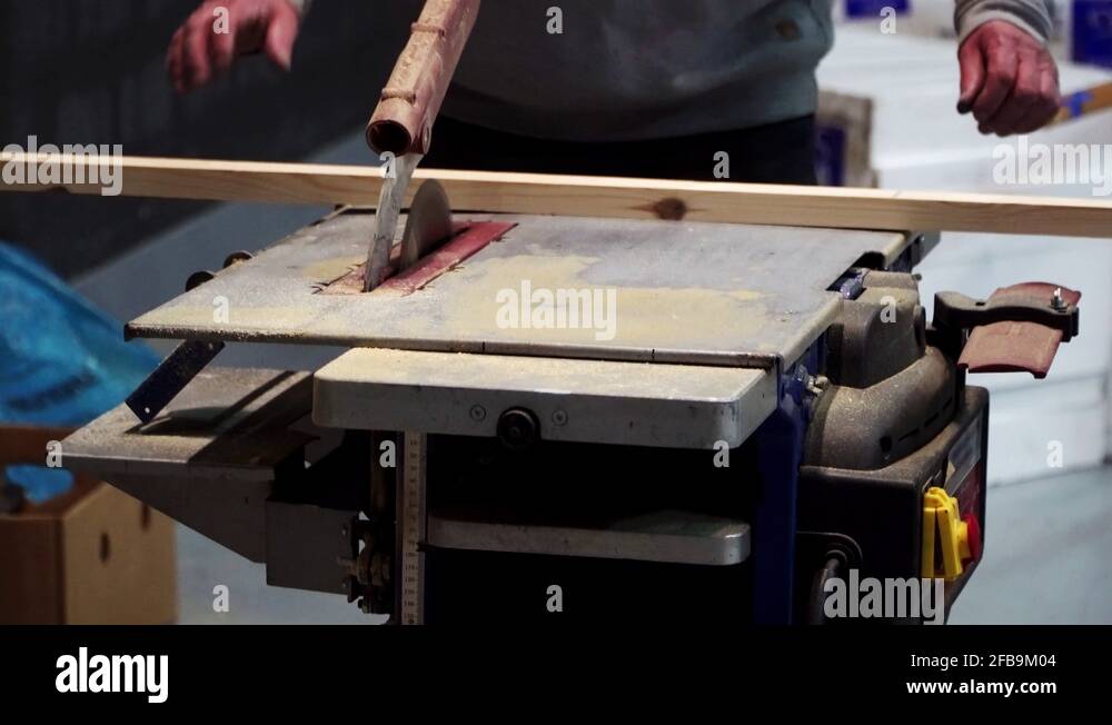 Hard labour work, wood sawing in a tool medium shot Stock