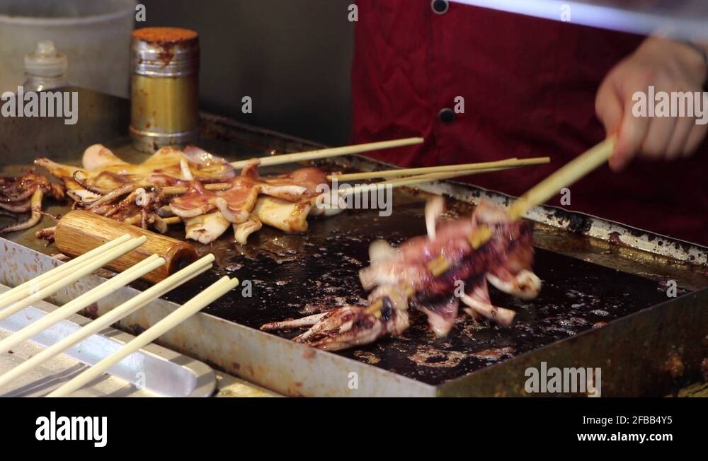 Chinese street vendor greasing fried squid, street food concept in Asia