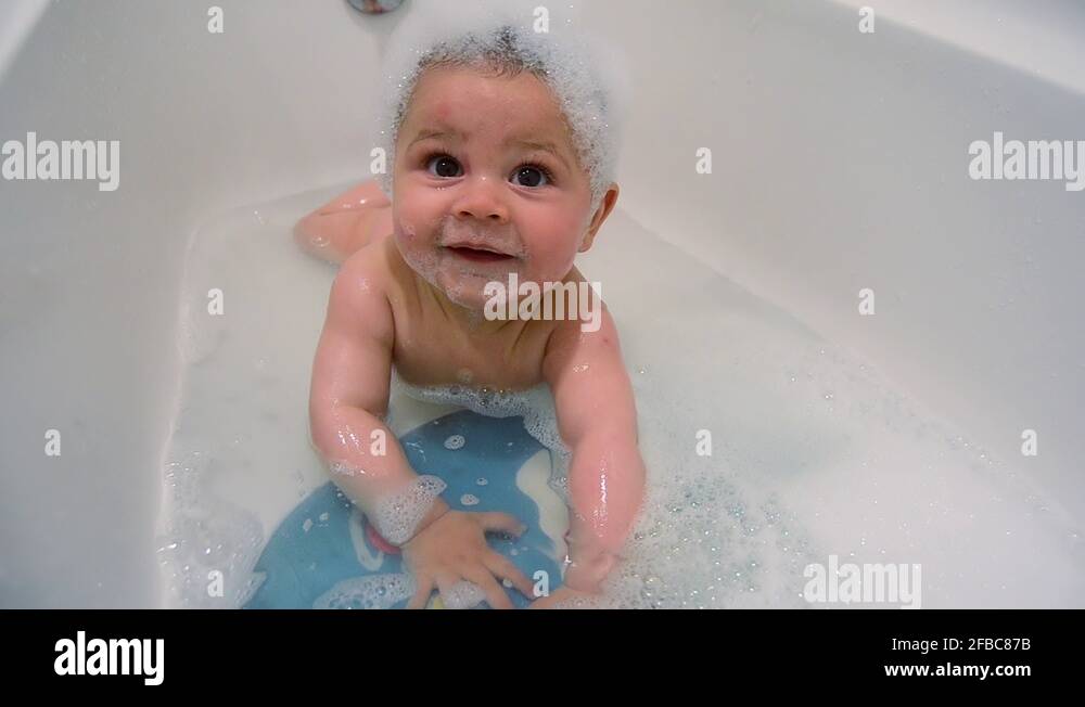 Cute six months old baby boy having a bath on his tummy Stock Video Footage Alamy