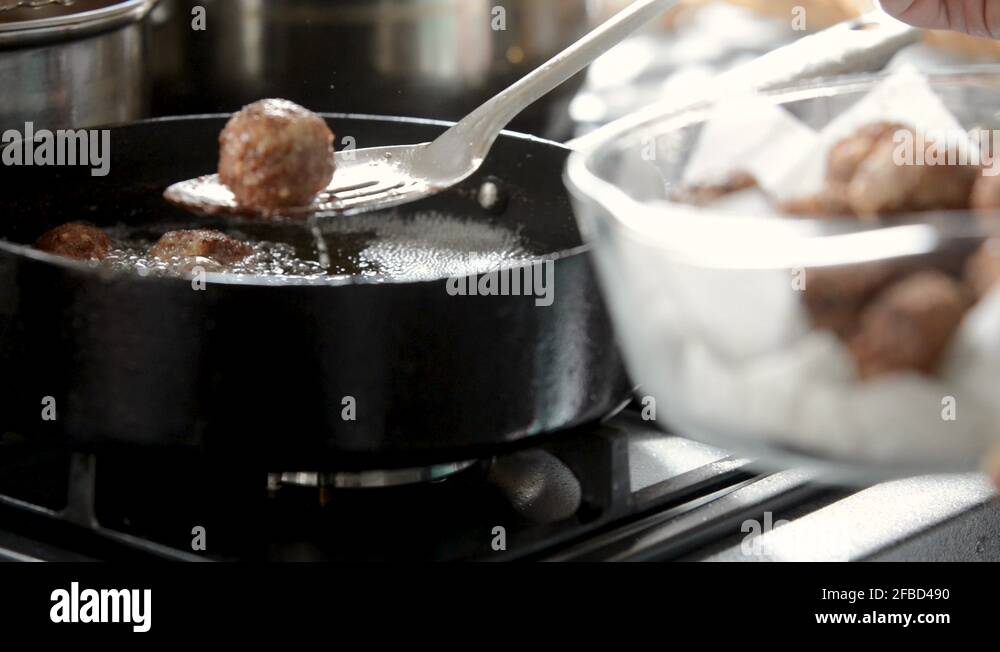 cooking meatballs in hot oil using a pan Stock Video Footage Alamy