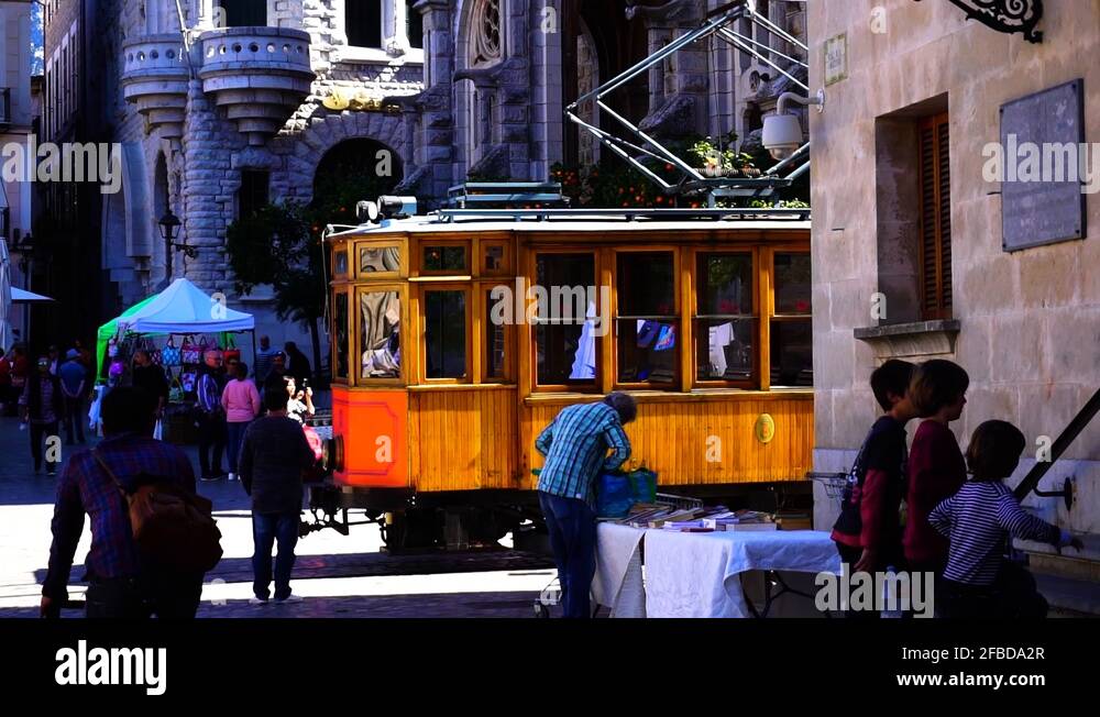 An electric cable car trolly driving through a city on the island of