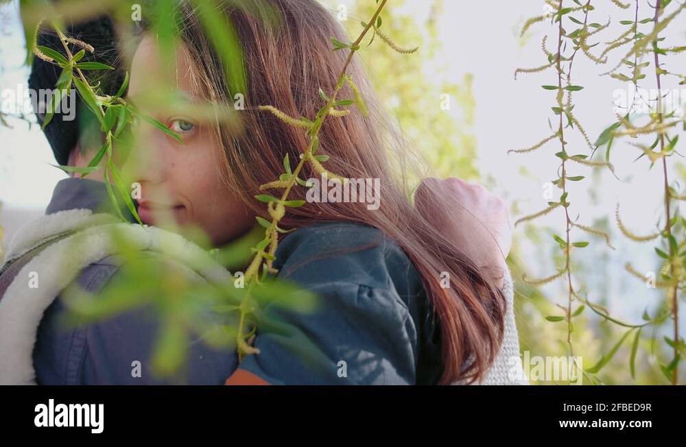 Young romantic couple hugging and girl lovely kisses boyfriend to neck