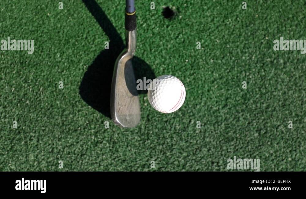 Golf club hitting a golf ball, tight shot, angle from above, slow