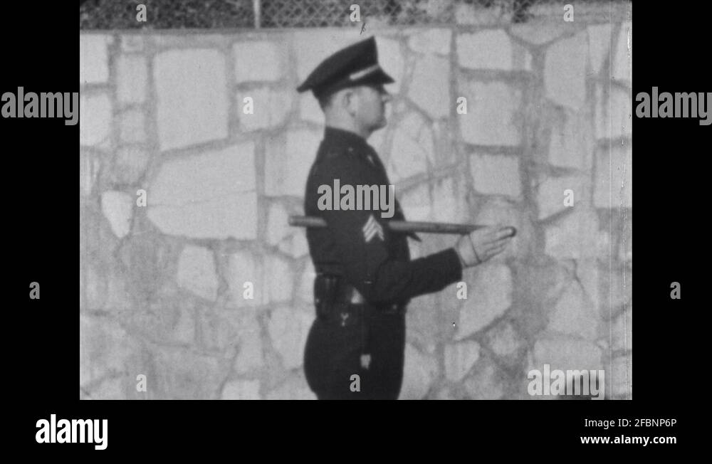 1960s Police officer demonstrates order arms position from side view