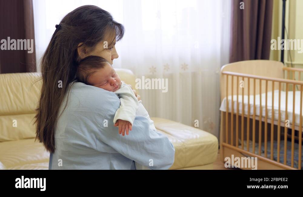 Lovely newborn baby sleeping on mother arms, carefree dreams Stock
