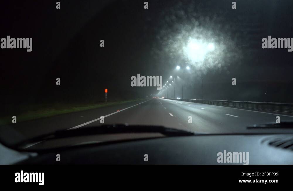 Handheld footage of car driving on an empty motorway / freeway at night ...