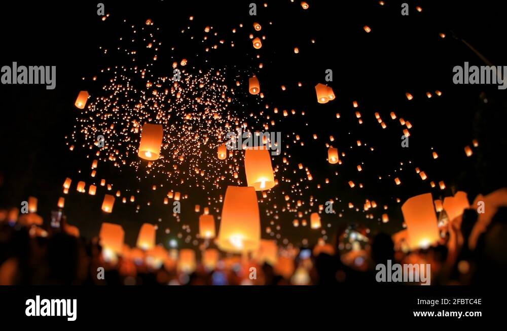 Lanterns of light is released into the night sky by multi ethnic crowd