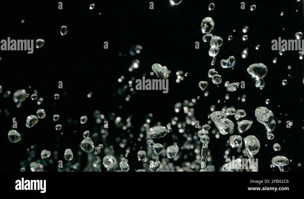 Water droplets rise in the air against Black Background. Slow motion ...
