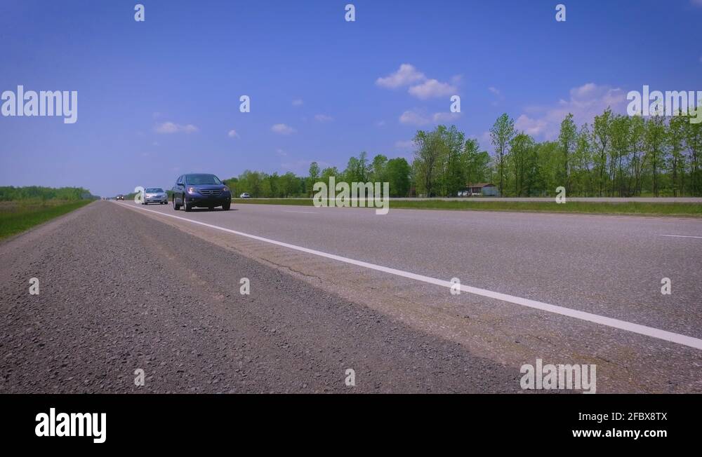 Cars driving down a busy freeway on a clear day Stock Video Footage Alamy