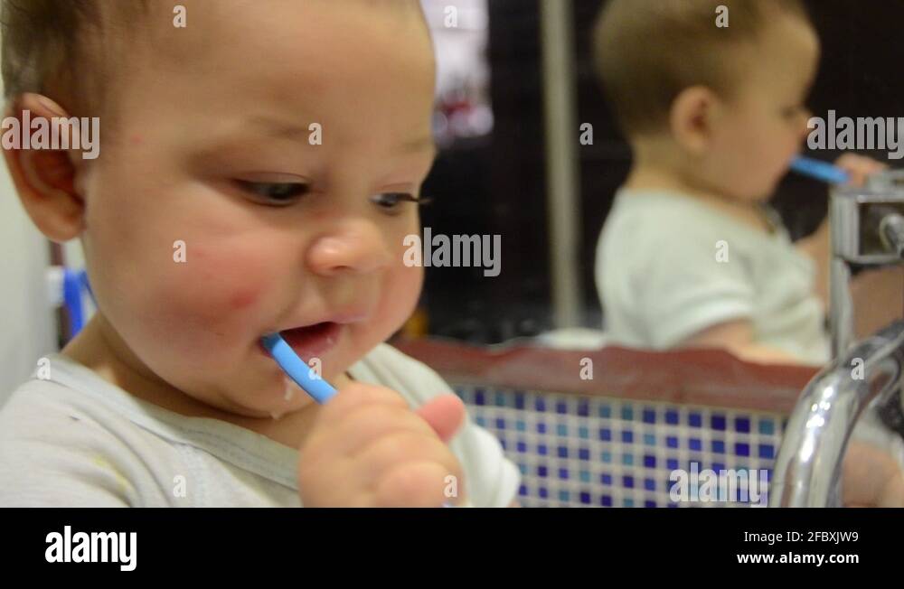 cute baby boy brushing his teeth. 7 months old teething baby using