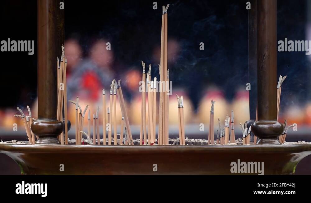 Hand sense joss stick to at an incense burn and burning candle in