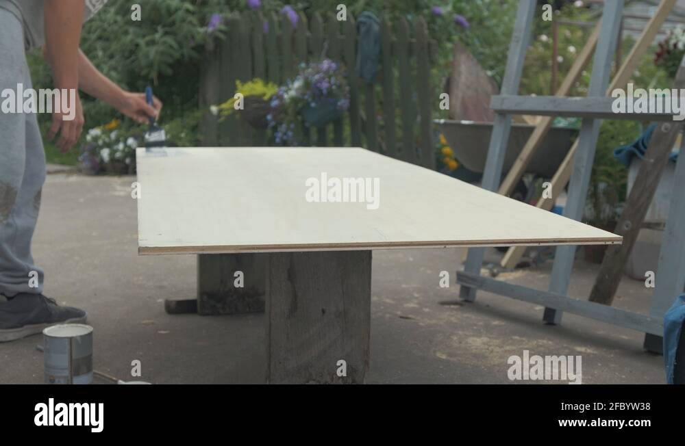 Painting ply wood sheet with exterior waterproofing paint Stock Video