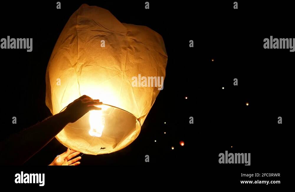 Floating Lanterns Are Lit And Hands Are Letting Go Of Them. Chinese