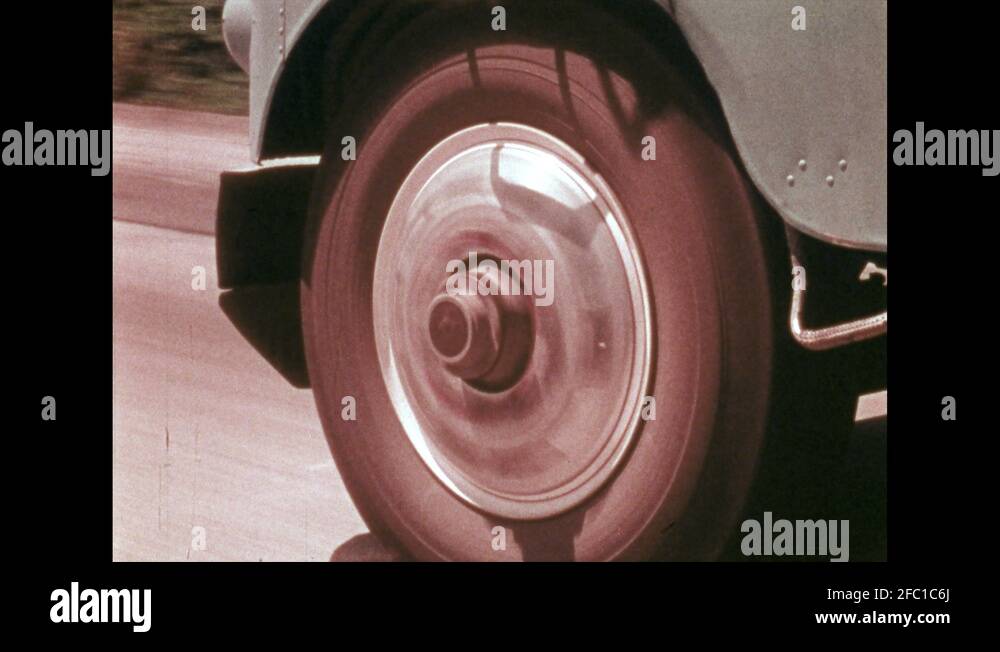 1970s Truck wheels spin on highway. Interstate sign on overpass