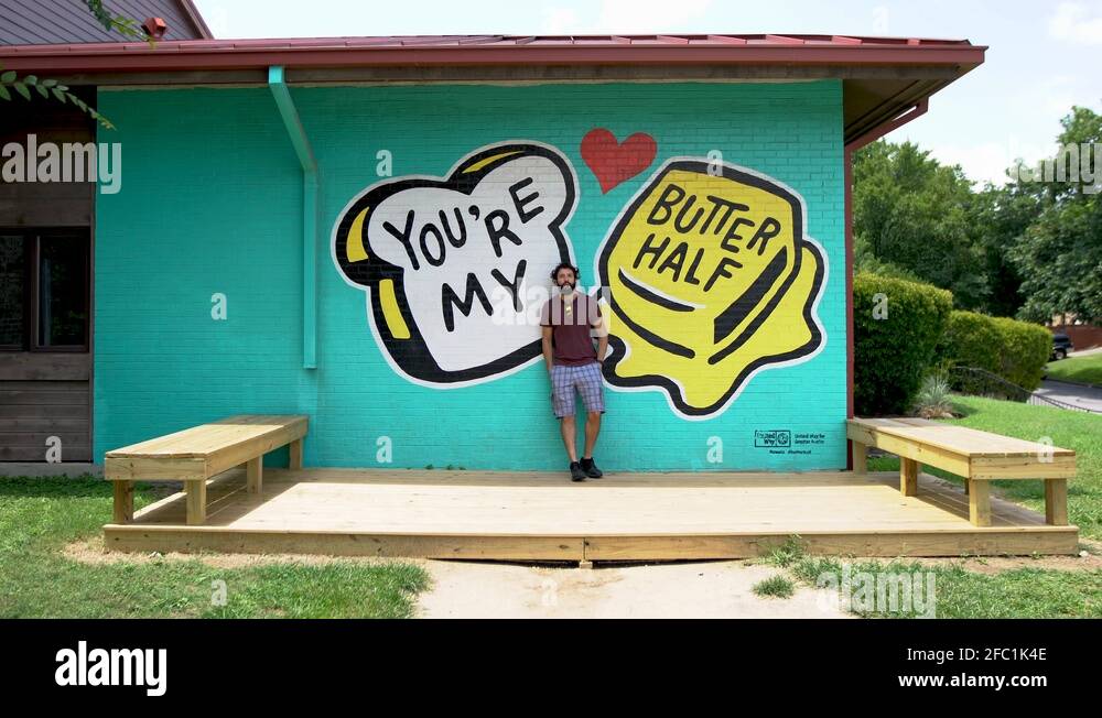 Famous graffiti art in Austin Texas, butter half wall mural. Man taking