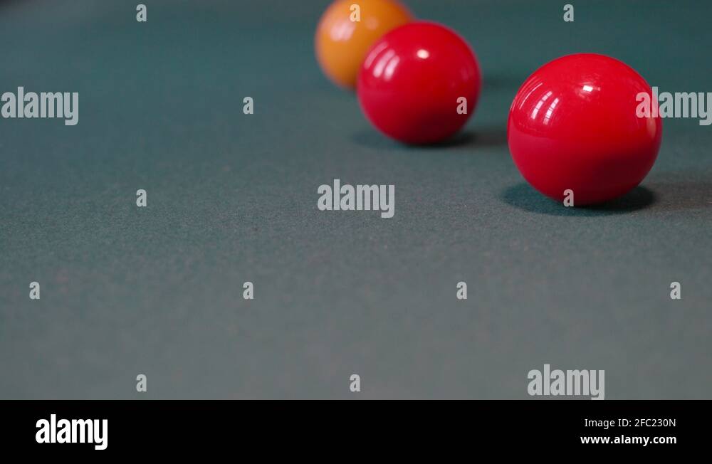 Red billiard balls rolling on the green game table at snooker club. 4K