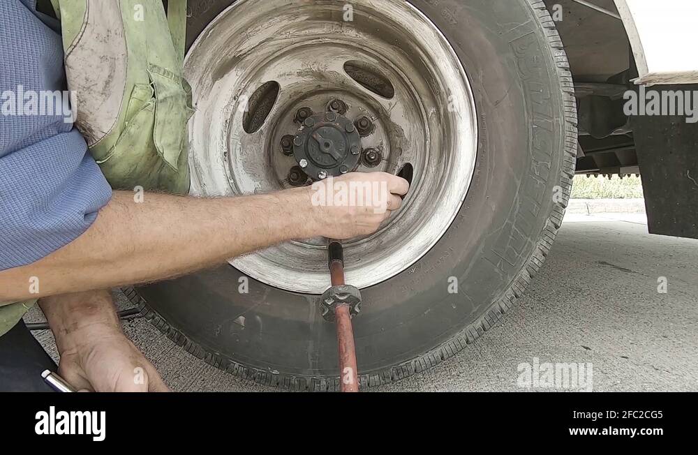Attaching air hose to truck tire after puncture repair Stock Video