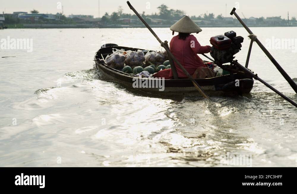 Female trader travelling by motorised wooden boat Vietnam Stock Video