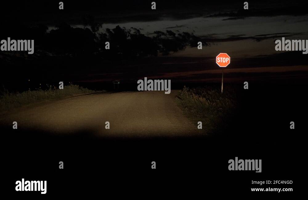 Pulling up to a stop sign at night on gravel road Stock Video Footage Alamy