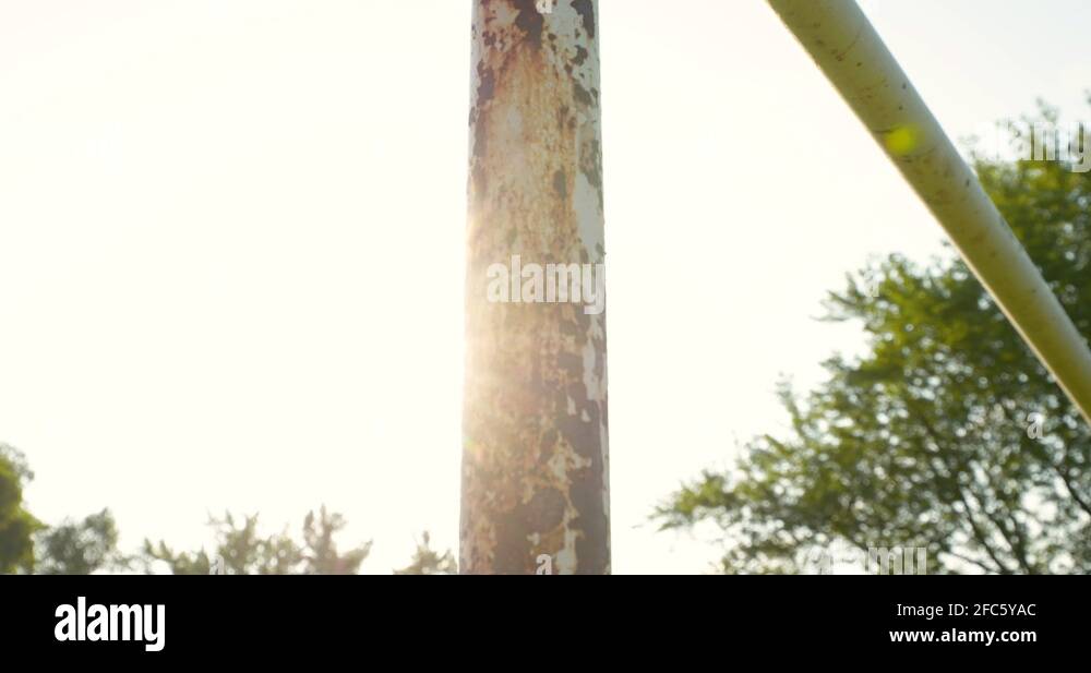 A lens flare dolly pan across a rusted old soccer goal post Stock Video Footage Alamy