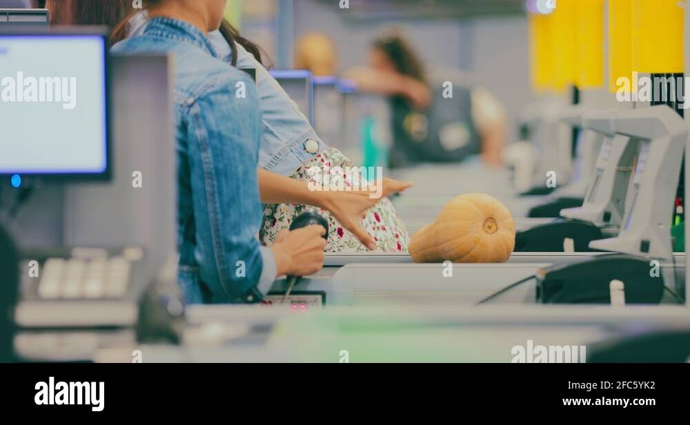 Cashier punches products at the checkout. Shopping at the supermarket