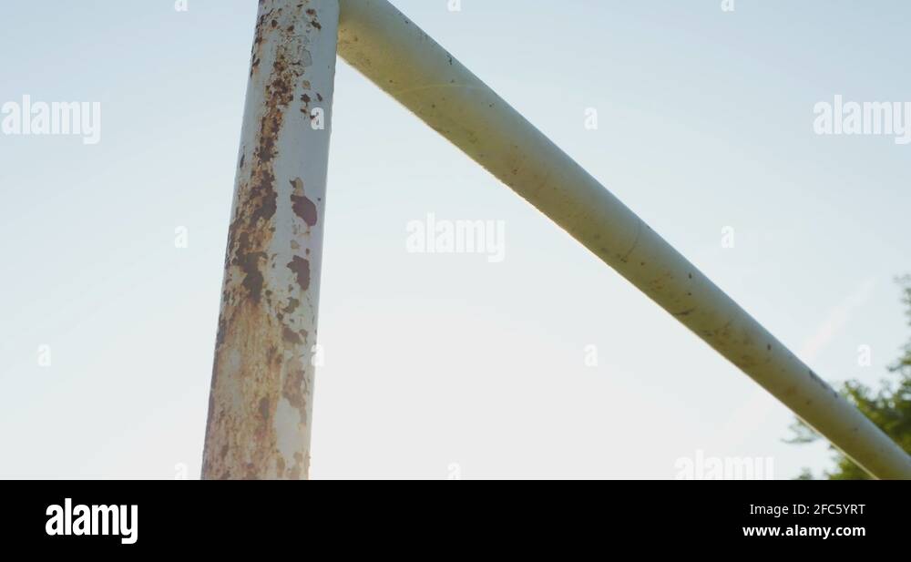 A lens flare dolly pan across a rusty, old, soccer goal post Stock Video Footage Alamy